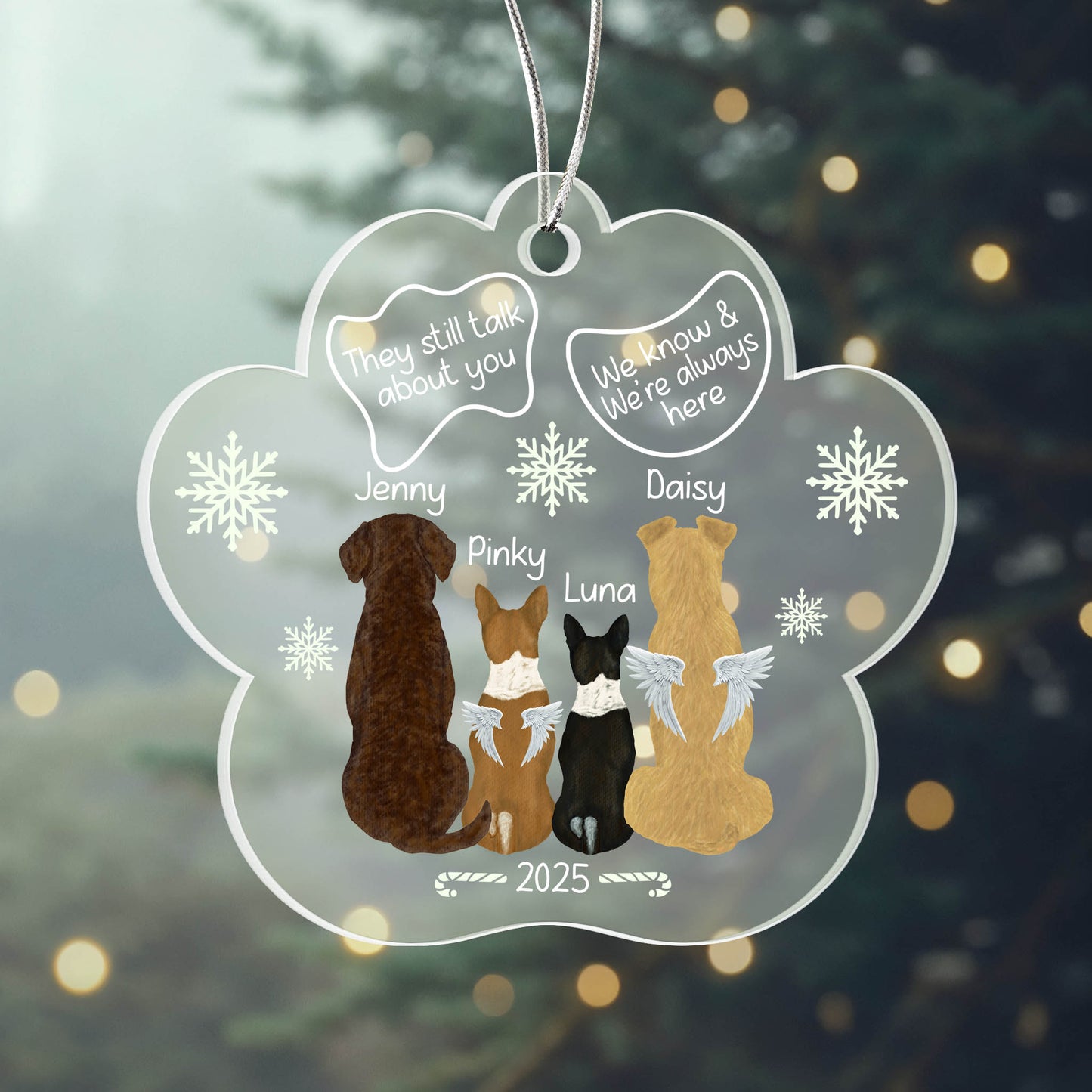 Decorative ornament with four dogs and text on a blurred Christmas tree background