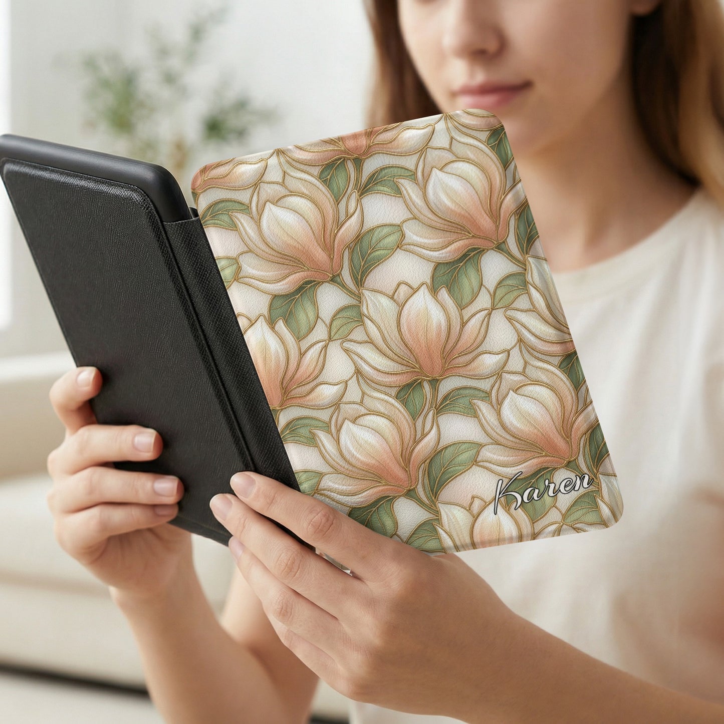 Woman holds e-reader with floral magnolia case signed "Karen".